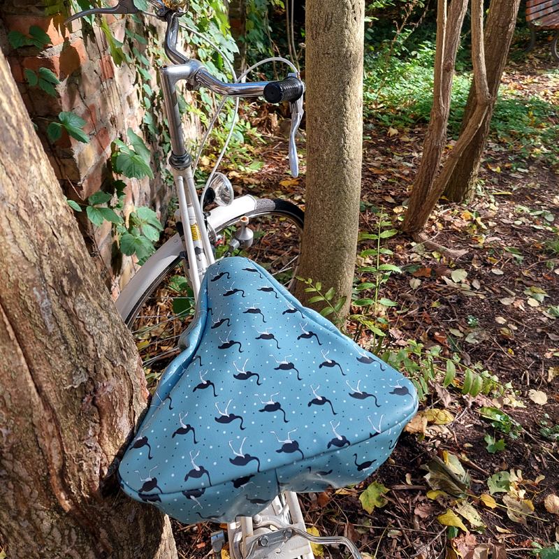 Ikuri Sattelschoner Avestruz auf einem Fahrradsattel vor einem Baum