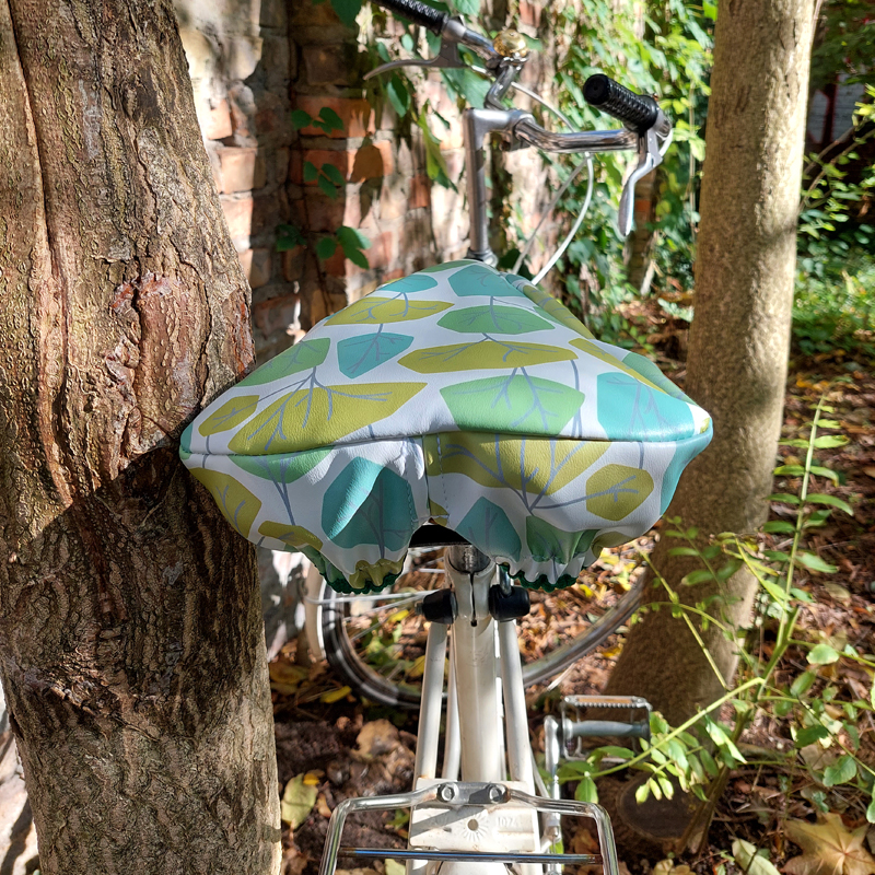 Ikuri Sattelschoner Bosque auf einem Fahrradsattel vor einem Baum
