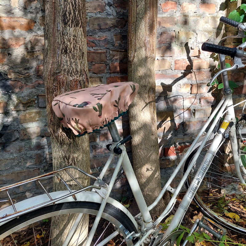 Damenrad mit Sattelbezug Cactus zwischen Bäumen