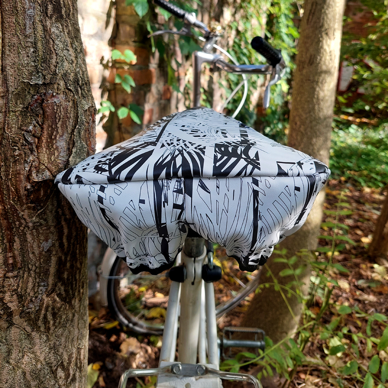 Ikuri Sattelschoner Palmeras auf einem Fahrradsattel vor einem Baum