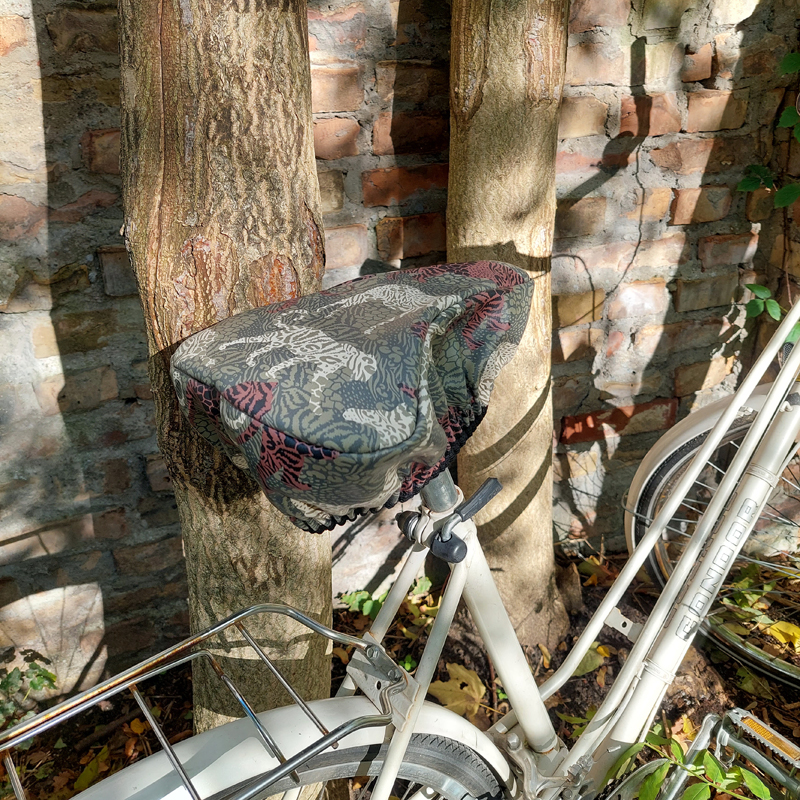 Damenrad mit Sattelbezug Animals vor einer Mauer
