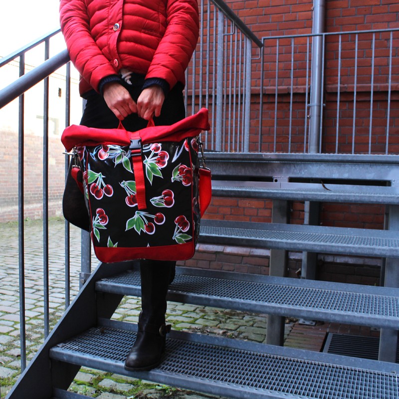 Umhängetasche Cerezas schwarz getragen auf einer Treppe, Nahaufnahme