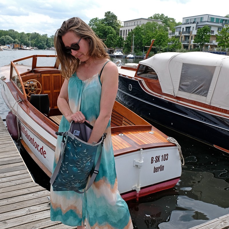 Frau im Sommerkleid öffnet den Drybag Marina am Hafen