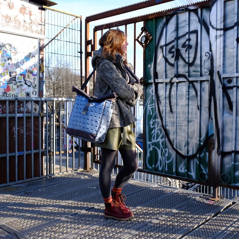 Frau trägt die Umhängetasche Avestruz vor Graffiti