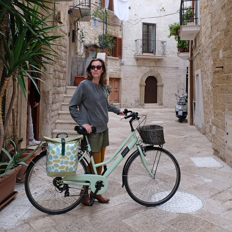 Frau mit Fahrrad und Seitentasche Bosque in einer Altstadtgasse