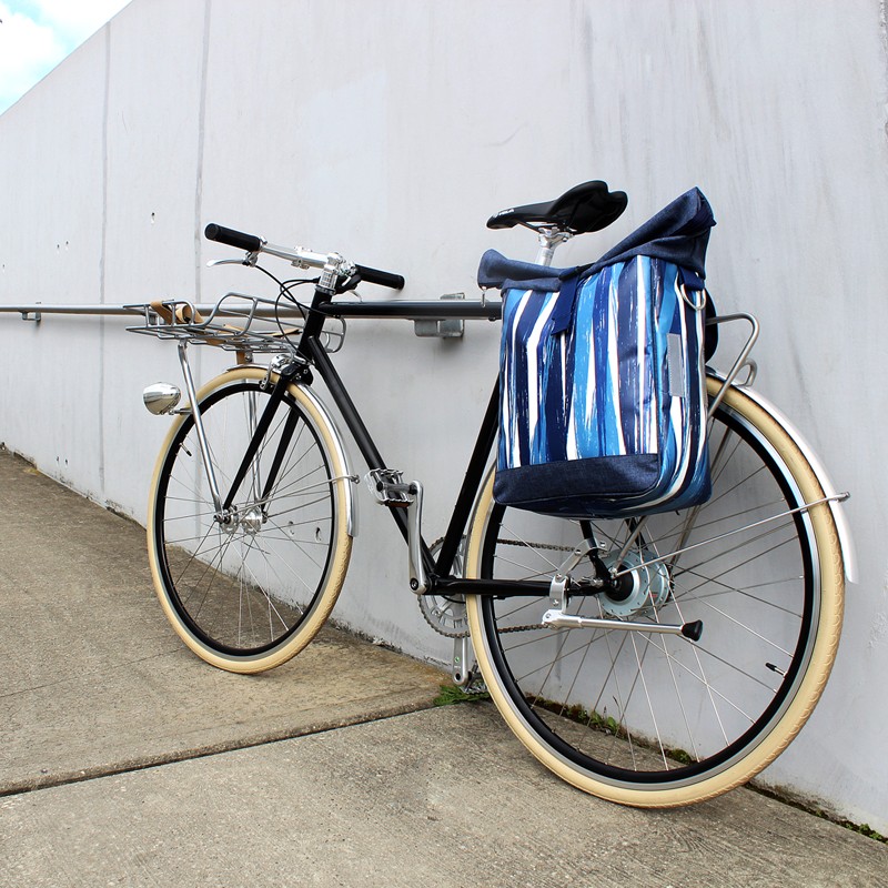 Fahrrad mit Seitentasche Indigo an einer weißen Wand