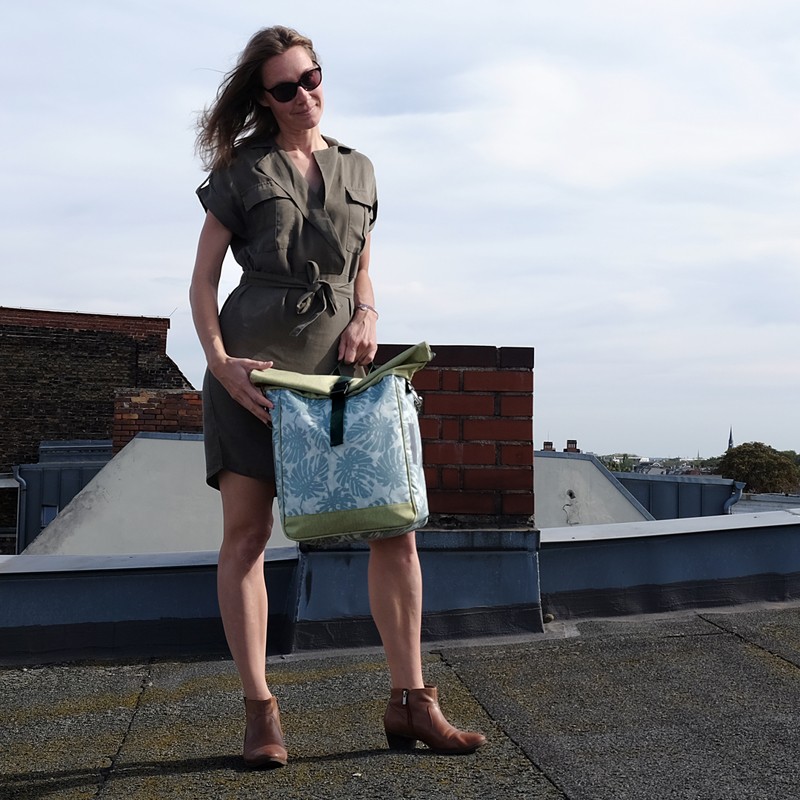 Frau trägt die Umhängetasche Monstera auf einer Dachterrasse