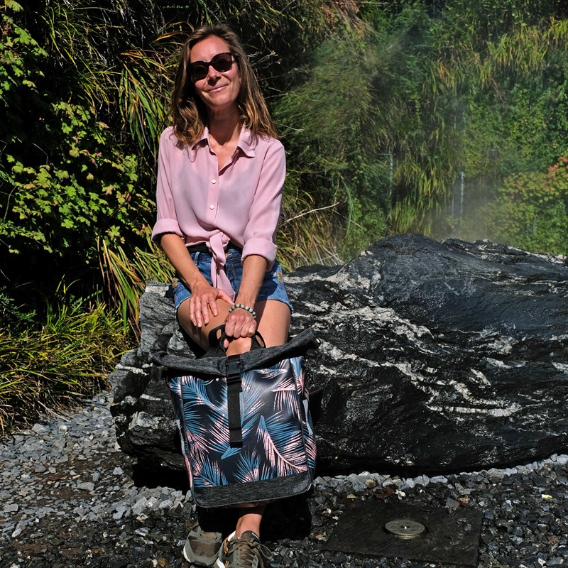 Frau hält die Tasche Retro Palma an Felsen am Wasser