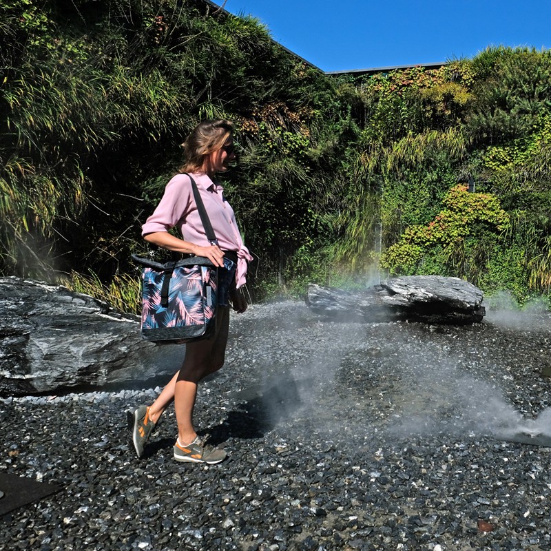 Frau trägt die Umhängetasche Retro Palma vor einem Wasserfall