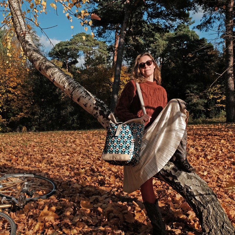 Frau mit Umhängetasche Scandinavia an einem Baum im Herbst