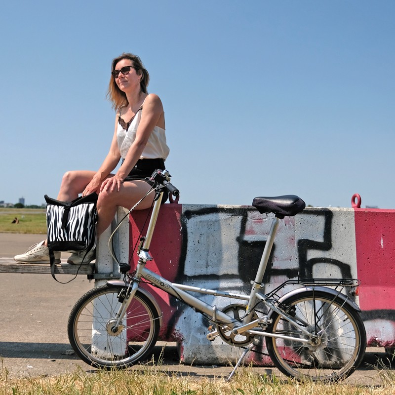 Frau unterwegs mit kleiner Fahrradtasche Zebra