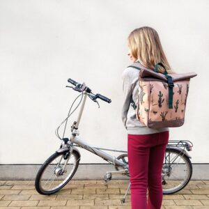Mädchen trägt den kleinen Rucksack Cactus von Ikuri neben einem Klapprad
