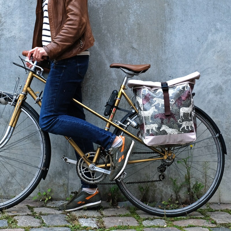 Frau mit Fahrrad, der Fahrradrucksack Animals hängt am Gepäckträger