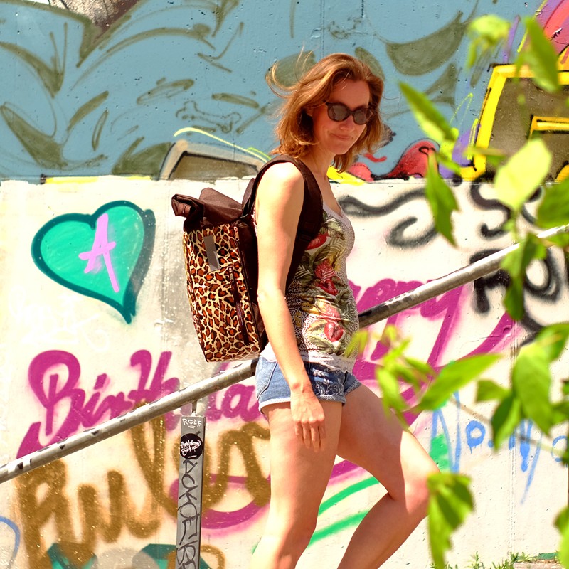 Frau mit Fahrradrucksack Damen Leopard vor bunter Graffiti-Wand