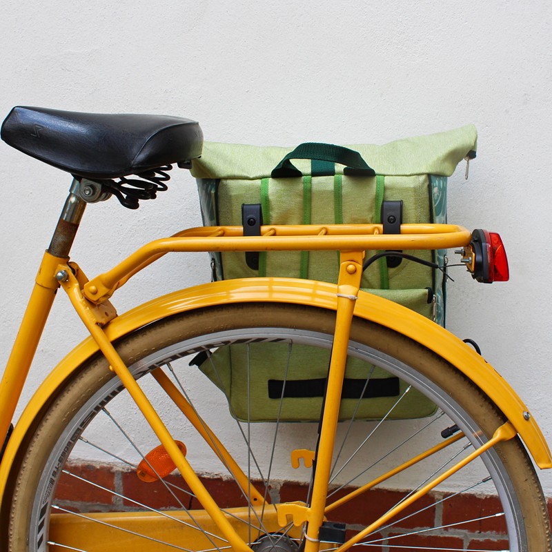 Kombi Fahrradtasche Rucksack Monstera am Gepäckträger eines gelben Fahrrads