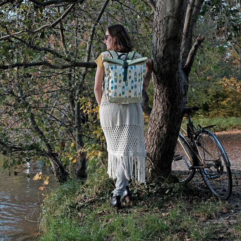 Frau trägt den Fahrradrucksack Surf als Rucksack im Wald am Wasser