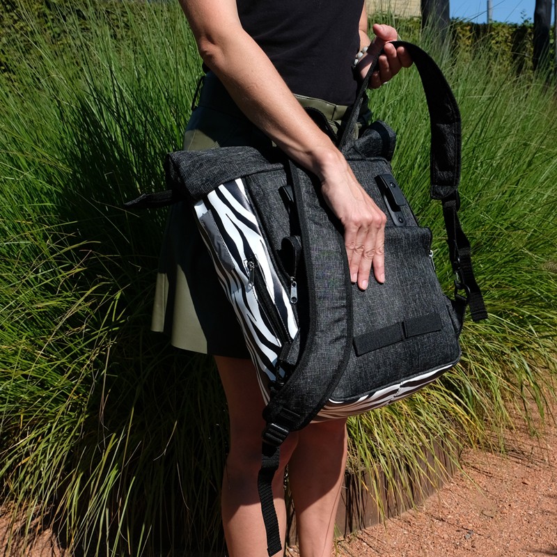 Frau hält den Rucksack Zebra, Blick auf die Rückseite mit Gurten