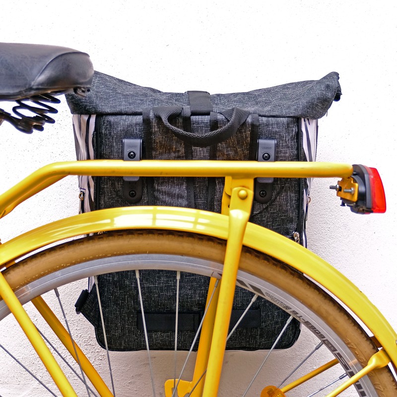 Ikuri Zebra als Fahrradtasche am Gepäckträger eines gelben Fahrrads