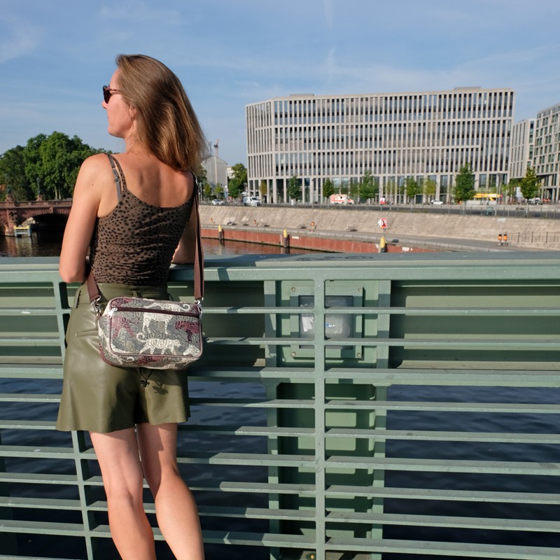 Frau trägt die Lenkerhandtasche Animals an einem Geländer
