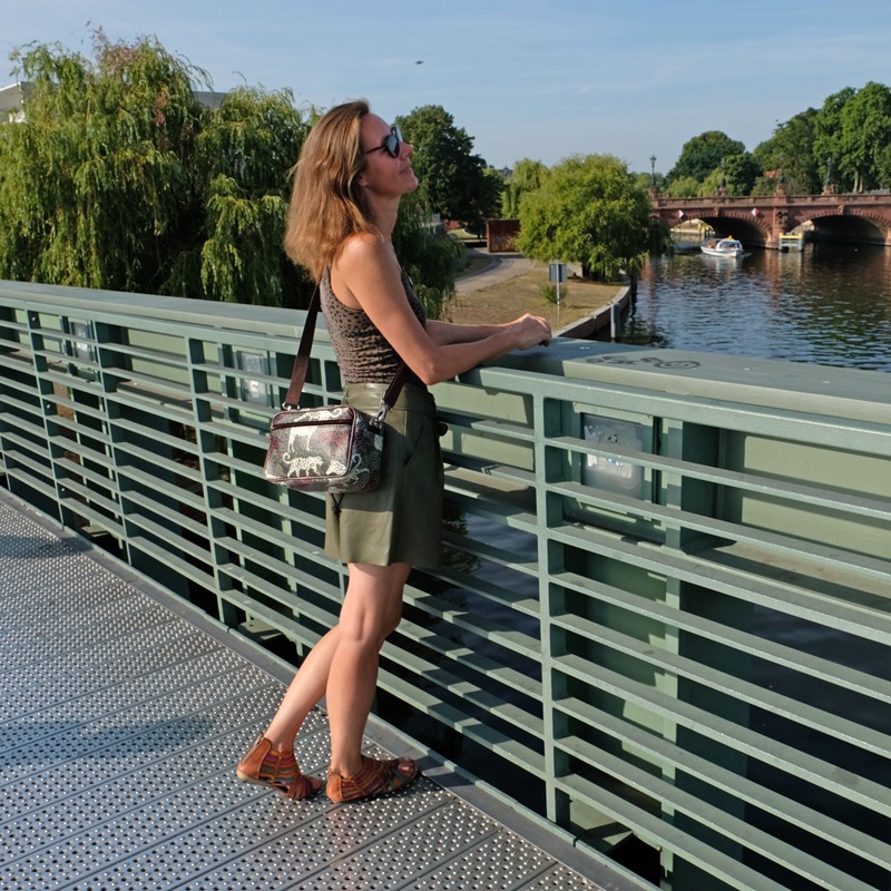 Frau mit Umhängetasche Animals auf einer Brücke