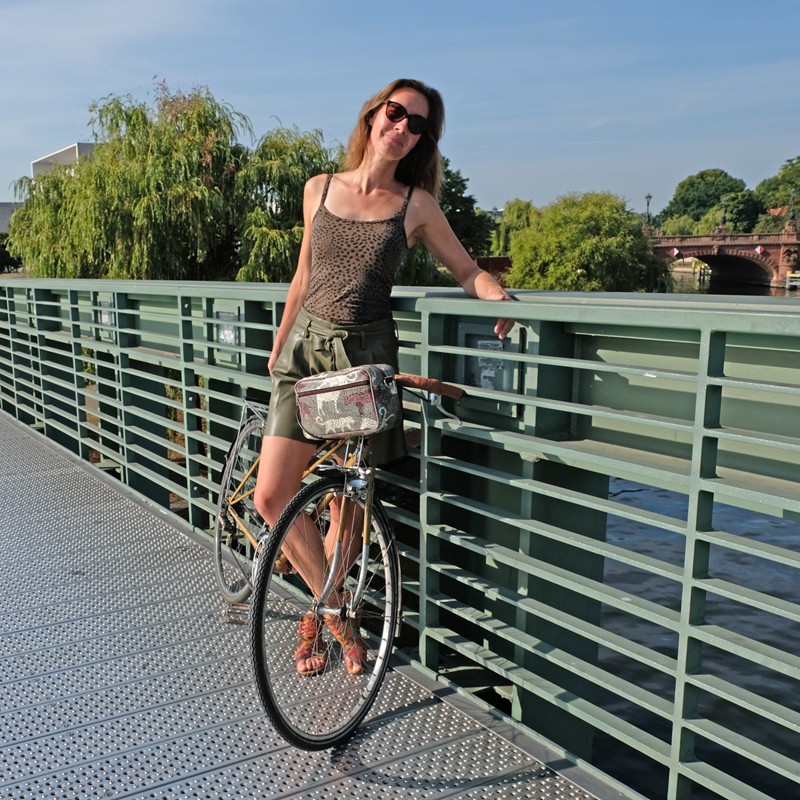 Frau mit Fahrrad und Lenkertasche Animals am Geländer