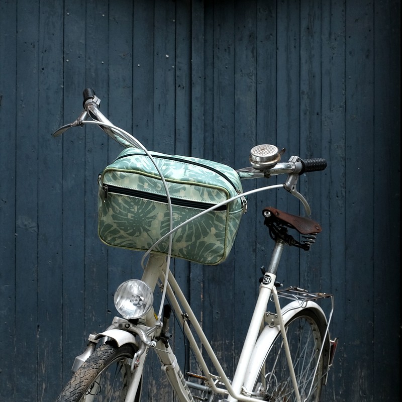 Lenkertasche Monstera am Fahrradlenker vor blauer Wand