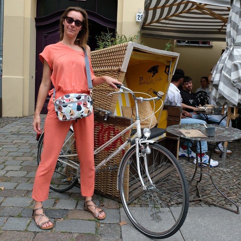 Frau mit Lenkerhandtasche Peras neben ihrem Fahrrad