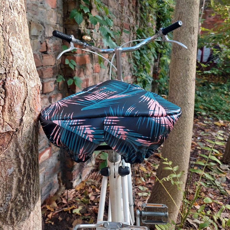 Ikuri Sattelschoner Retro Palma auf einem Fahrradsattel vor einem Baum