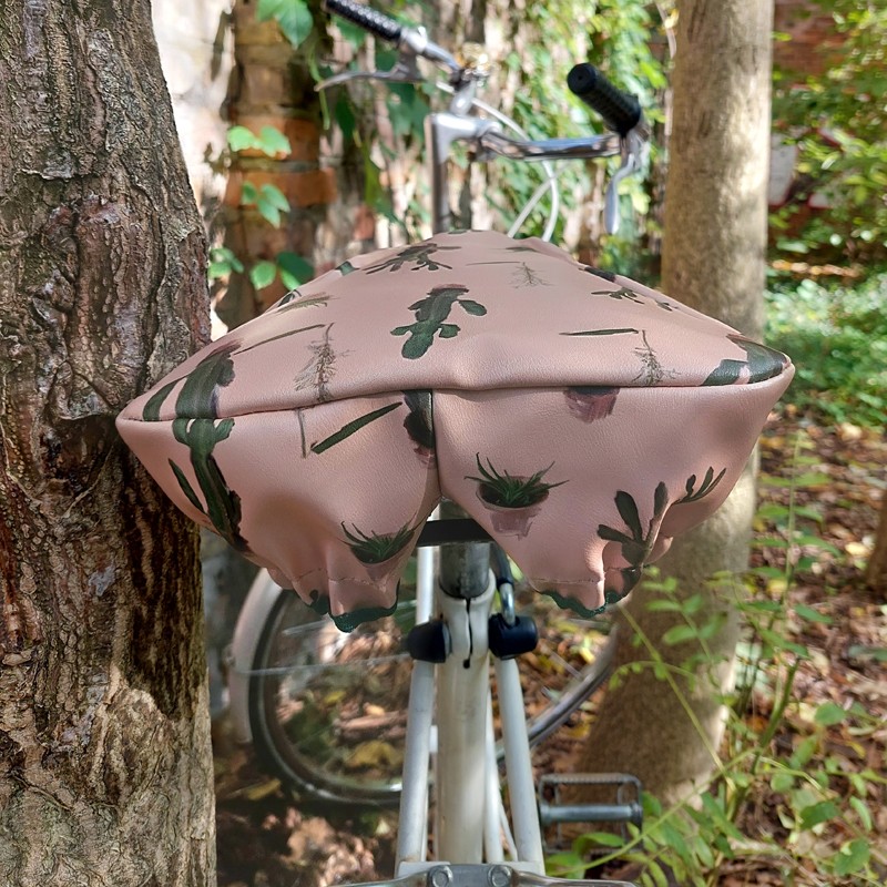 Ikuri Sattelschoner Cactus auf einem Fahrradsattel vor einem Baum
