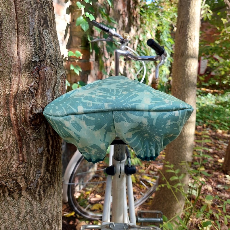 Damenrad mit Sattelbezug Monstera zwischen Bäumen