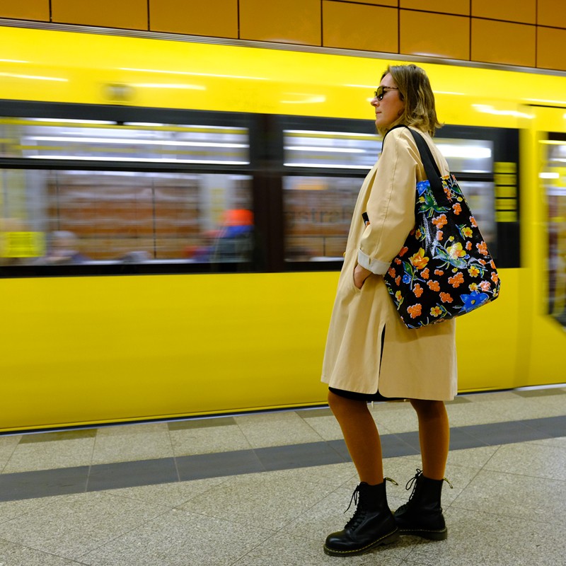 Frau trägt die Einkaufstasche Floral am Bahnsteig