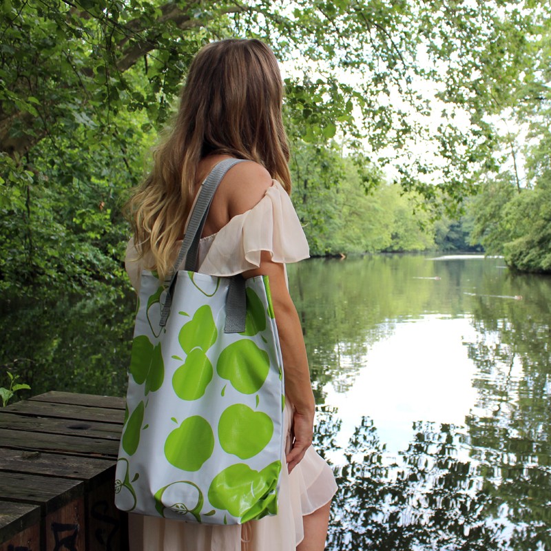 Frau mit Shopper Manzanas grün am Wasser