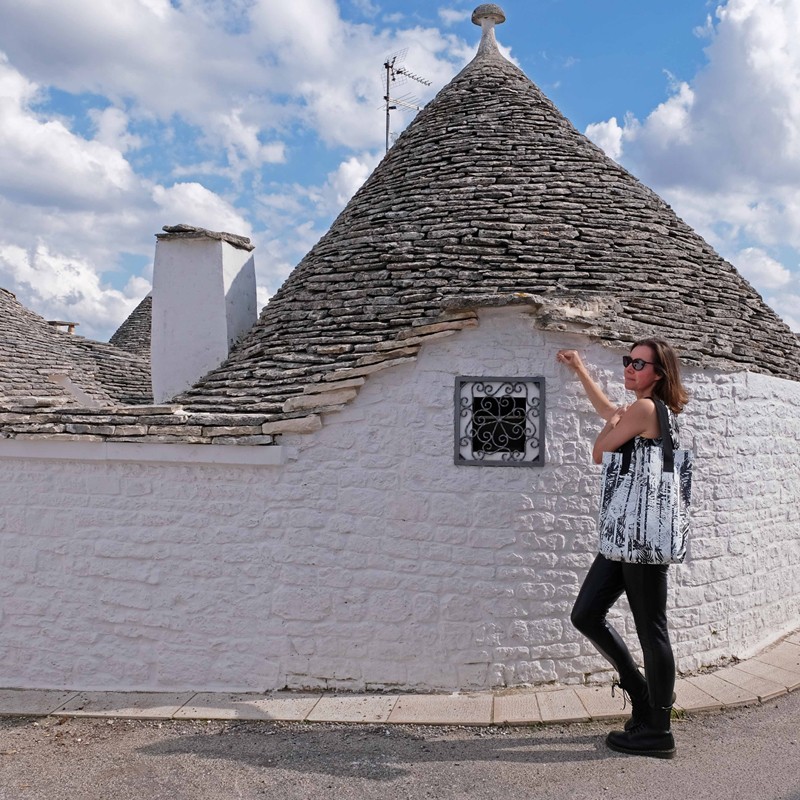 Frau mit Shopper Palmeras vor einem Trullo