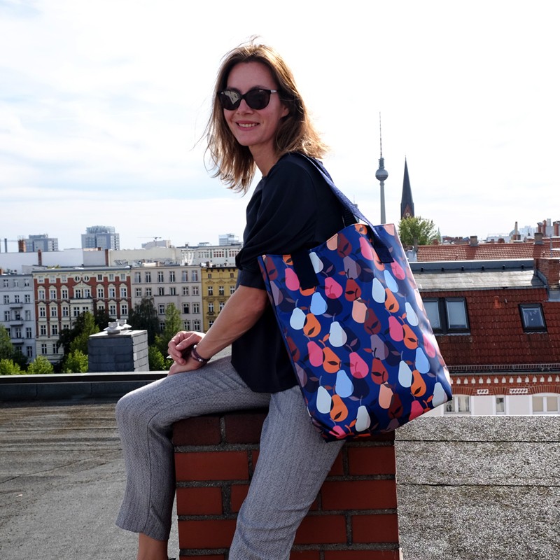 Frau sitzt auf einer Dachterrasse mit dem Shopper Peras blau