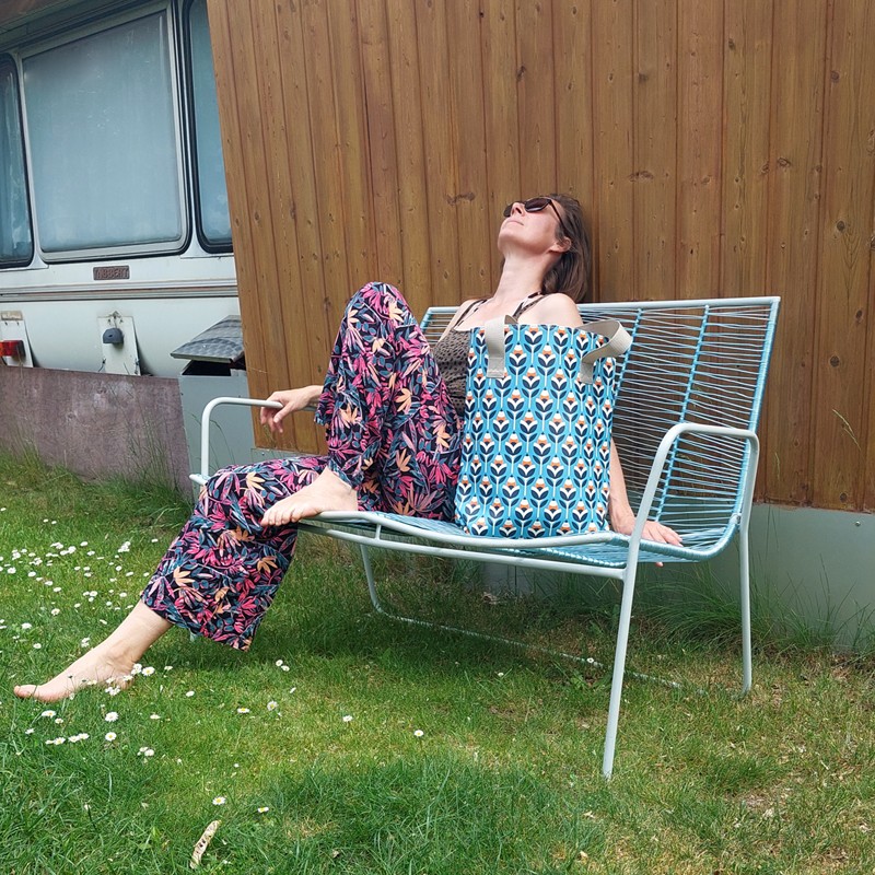Frau sitzt auf einer Gartenbank mit dem Shopper Scandinavia